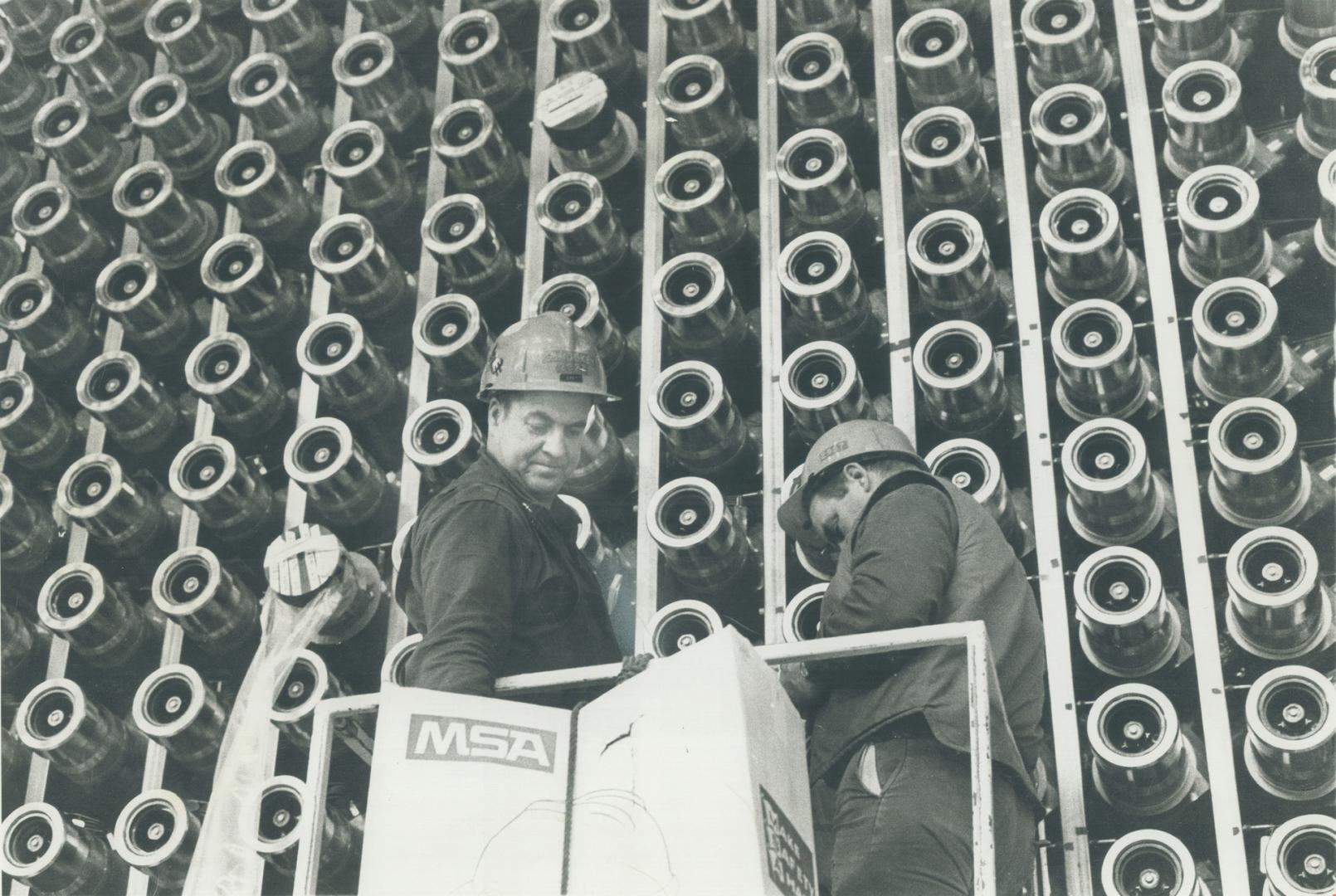 Deep in the heart of one four nuclear reactors at Pickering power station, technicians prepare tubes that will contain fuel rods when the plant begins producing power within tow months