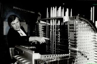 Trouble spot: Jack Muir, Pickering spokesman, points to problem area on model of reactor (above), and holds fuel bundle (right)