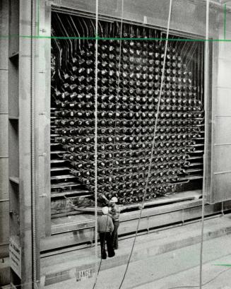 Workmen check fueling rods on reactor under construction, above, in station's control room, are right, Bill Harvey, Henry Stevens and first operator Mike Stone