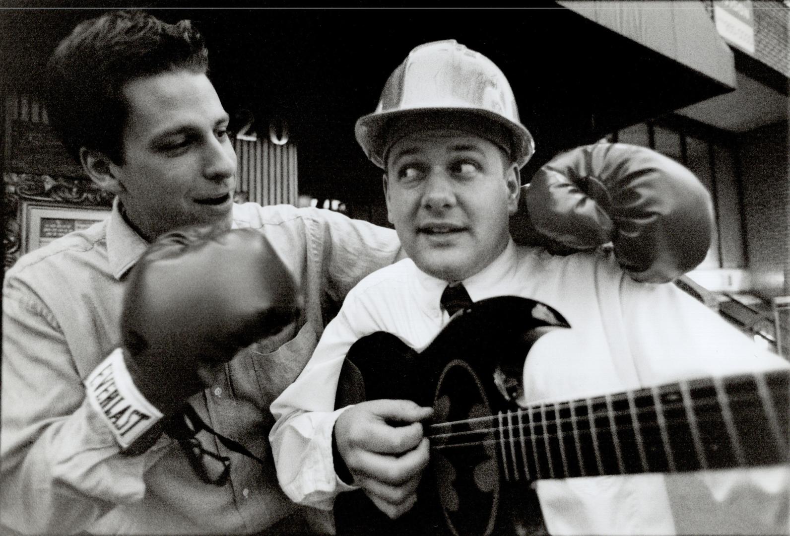Punching out a tune. Jody Palubiski spars in Muhammad Ali's gloves, as Doug Fowles twangs out a tune on a Batman guitar. Both items will be on the blo(...)