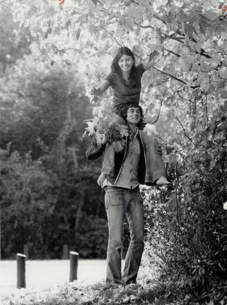 Collecting autumn leaves in Morningside Park, 21-year-old Beth Lamb rides on the shoulders of Robert Kalisz, also 21