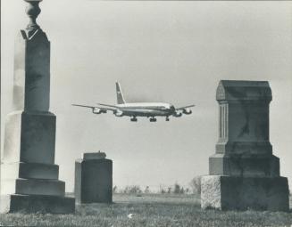 A Boeing 707 prepares to land at Toronto International Airport past a pioneer cemetery between two runways