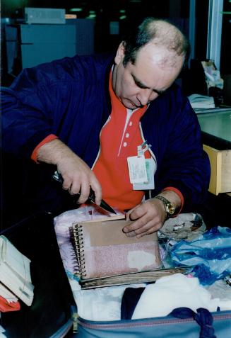Thorough search: Customs official Bob Sereda uses a knife to probe luggage at Pearson