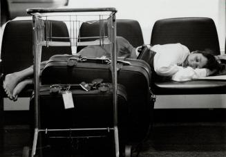 Barefoot at the airport: An unidentified traveller snoozes yesterday at Terminal 2 in peaceful respite from the frustration at Pearson International Airport caused by striking federal civil servants