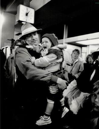 Where's my ride? A tired 2-year-old Eric Simpson cries in arms of his father, John Simpson of Huntsville, at Pearson Airport late Saturday. The family faced a long wait for a limo or taxi