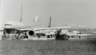 Waiting turns: Airplanes stand in line on the runway at Pearson Airport yesterday following a wildcat walkout by eight out of 10 air traffic controllers on the day shift