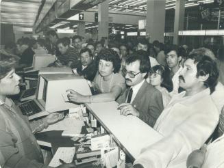 A CP Air worker (left) at Pearson International Airport does her best to explain a foul-up in flight plans to furious passengers who were grounded ins(...)