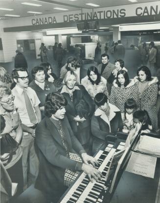 Waiting in terminal 2 at Toronto International Airport for their flights to be called last night, air Canada passengers sing carols, accompanied by We(...)