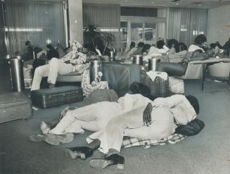 Passengers removed from a Jamaica-to-Montreal flight last night sleep on benches at Toronto International Airport