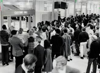 Crowds of newly arrived air passengers wait to go through customs at Toronto International Airport
