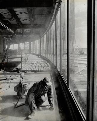 Workman readies floor in interior of Jetport