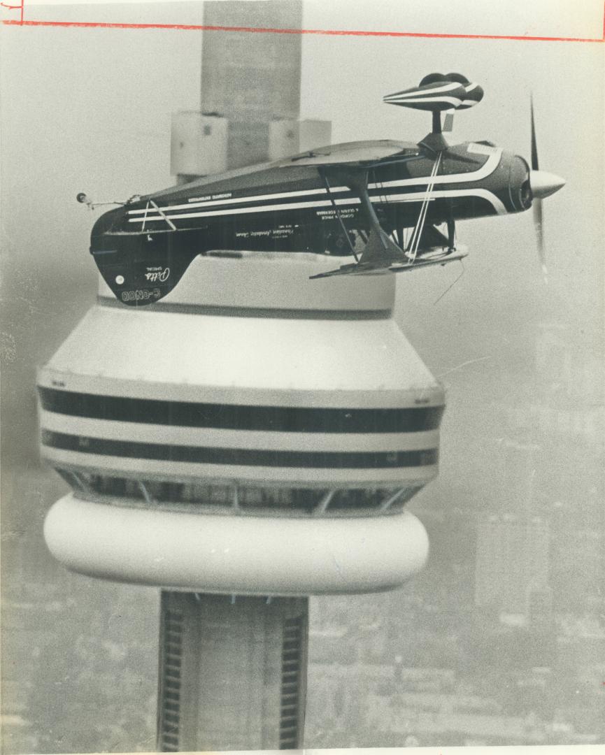Plane sight. Stunt flyer Gordon Price takes his Pitts Special biplane upside down past the C Tower yesterday. He staged the stunt to dramatize the pli(...)