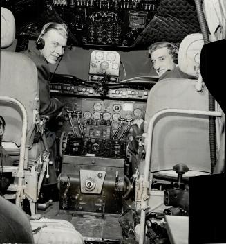In cockpit of the R.C.A.F. North Star which carried Gordon Jarrett, Toronto ex-flying officer, on his just completed two-way ocean crossing are F.O. Earl Banks, pilot, and F.O. G. W. Webb