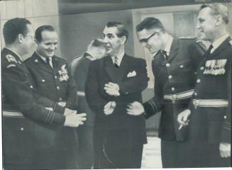 Commanding Conversation. Conversation is about airplanes after change in command ceremony at Ave Rd. RCAF station. From left: W/C J. N. Swanson, S/L N(...)