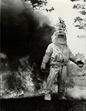 To drag injured airmen from crashed planes or burning buildings, the training station firemen don asbestos crash suits and plunge into the blaze. Pictured is a ghost