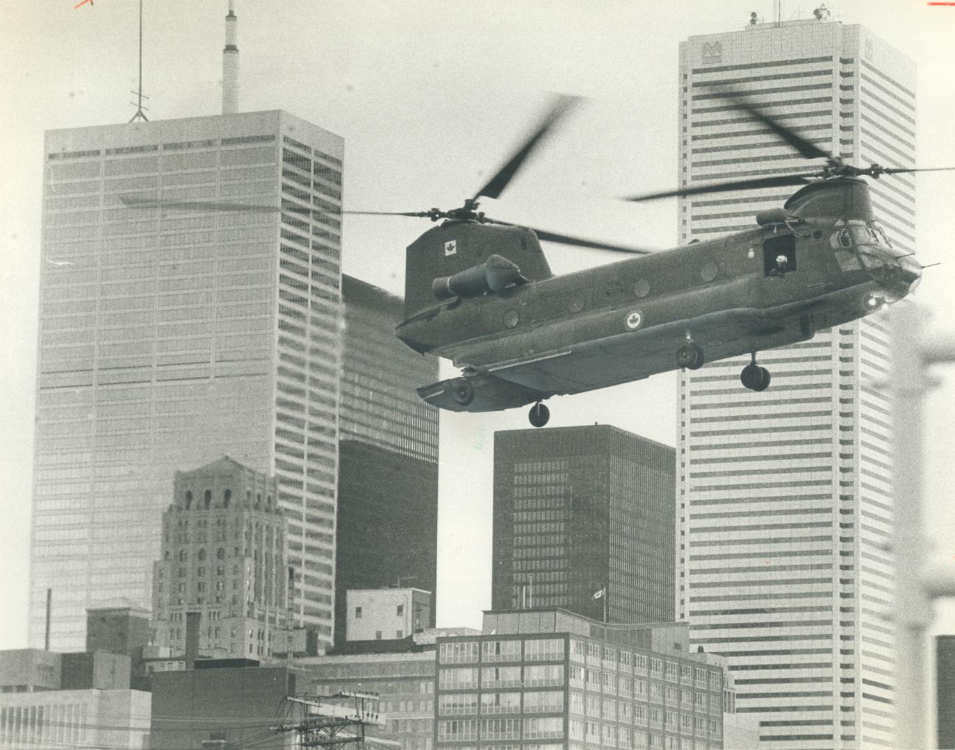 Swoosh. One of two Chinook helicopters cuts quite a swath over Metro's skies yesterday on its way to Moss Park Armouries. The choppers picked up 100 m(...)