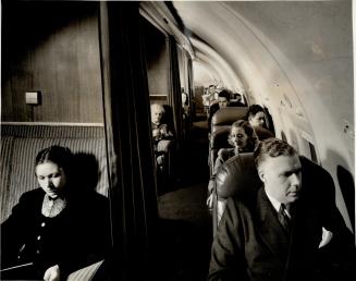 The roominess of a Strato-Clipper's passenger cabin is illustrated by this photograph taken from the aisle at the front of the cabin. The young lady a(...)