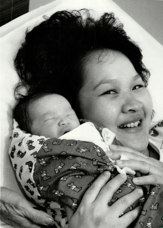 Nhan-Thi Tran, cuddles her newborn baby daughter, born at 10