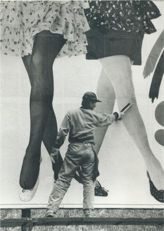 Brushing out the wrinkles. Jeff Uong may look like Gulliver in the land of the giants, but the larger-than-life legs are part of a billboard advertise(...)
