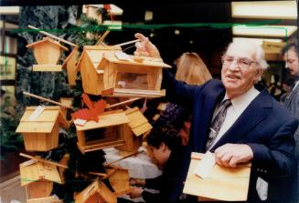 Irvin Robson with bird feeders and birds houses he made