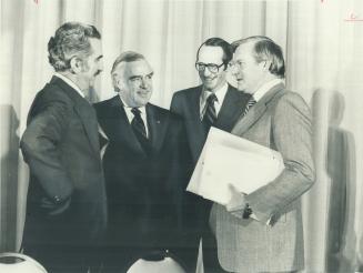 Just before submitting his presentation to a Toronto meeting of Task Force on Canadian Unity, Premier William Davis (right) confers with Jean-Luc Pepi(...)