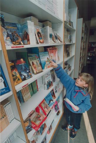 Kate Burgess of Ottawa reaches for a book at Toronto's Children's Book Store, a weekend mecca for families