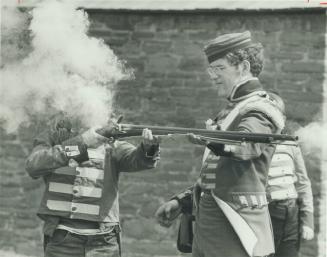 . . . fire! The old-time weapon belches smoke - enough to make the young gunner seem to lose his head