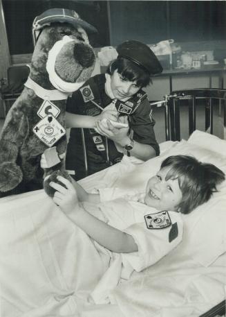 A helping hand: A bandaged mascot, and friend Michael Drudge, stand over injured Scout Sean Finucane at Hospital for Sick Children