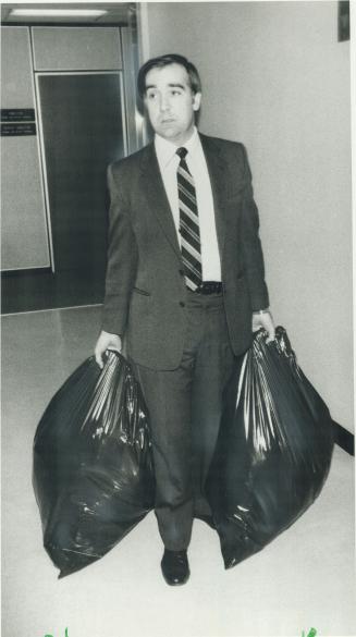 In the bag: OPP Det-Sgt. Chris Coles carries garbage bags turned in by the Globe