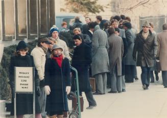 Cooling their heels on budget day, Kim Gagne, 23, (left) and Cheryl McCombe, 24, wait at the head of a line yesterday to pick up copies of Finance Min(...)