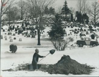 A grave digger prepares a last resting place in a cemetery just north of richmond hill