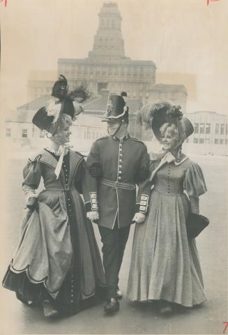 Off to celebrate centennial, Wearing the dress of 100 years ago, Dyanne (left) and Kathryn Rice are escorted toward City Hall by Ken Withers, in a per(...)