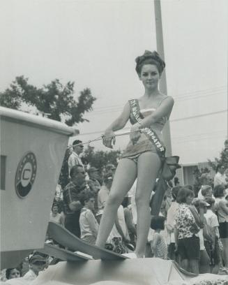 Miss Ontario underwater, sweetheart of the scuba diving set, rides high on a pair of water skiis aboard a float in Etobicoke's Dominion Day parade Sat(...)