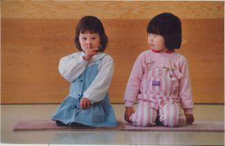 Quiet please: Jennifer Shirlaw, 3, signals for silence during a kids arts class at South Common community centre as Saori Ikeda, also 3, looks on