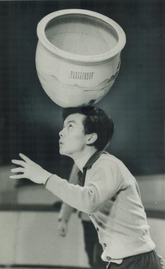 Using his head: Wn Nin, a performer in The Great Circus of China at the CNE Coliseum, keeps his eyes up while balancing an immense pot during rehearsals yesterday