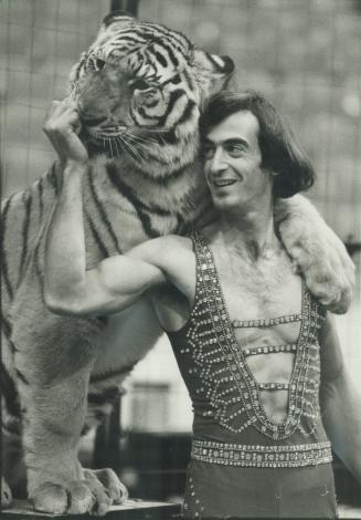Nice kitty: Trainer Wayne Ragen, 26, is having his hand licked, not his nails trimmed, by sam, a 250-pound Bengal tiger at the Garden Brothers Circus, Which opens tonight at Maple Leaf Gardens