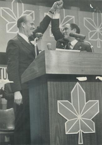 Runner-up Robert Winters lifts Pierre Trudeau's hand in victory symbol after fourth ballot