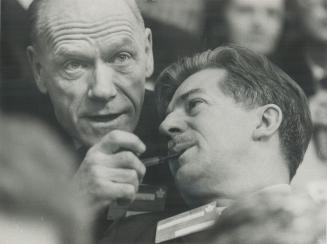 Wonder what they're discussing? Finance Minister Mitchell Sharp (Left) and Manpower Minister Jean Marchand get their heads together during last night'(...)