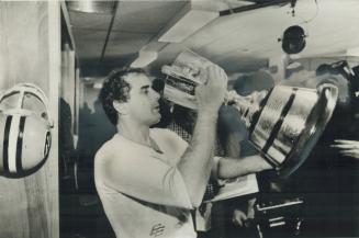 Edmonton quarterback Tom Wilkinson, who may have played his final game yesterday, enjoys a taste of champagne from the Grey Cup
