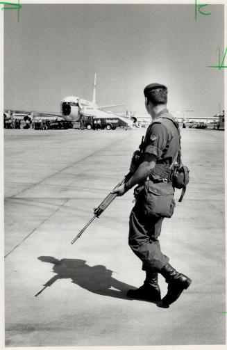 Taking no chances: A security officer stands guard at Pearson Airport as the leaders begin to arrive for the Toronto Economic Summit