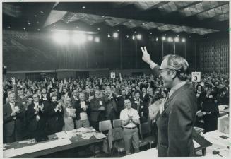 T. C. Douglas, federal leader of the New Democratic Party, waves a victory sign to the Ontario NDP convention today after calling for nationalization (...)