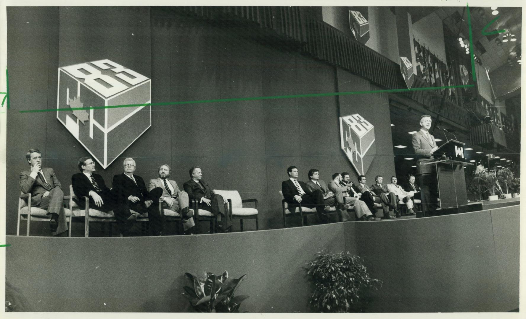 Candidates and officials listen as interim leader Erik Nielsen addresses opening convention