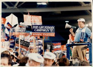 Whipping up the troops. A Larry Grossman campaign worker bellows through a bullhorn to a sea of delegates in the frenzy of the Tory convention last ni(...)