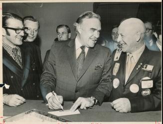 Registering at convention to choose his successor, Premier John Robarts chats with delegate Cecil Terry, right, of Levack, north of Sudbury, and Allan(...)