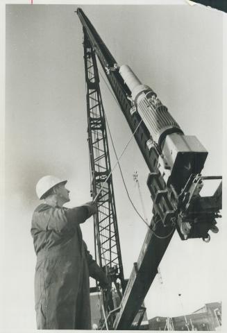Pile driving man. Workman Cal Barnes shows off a Three-and-a-half-ton Berminghammer pile driver at the Canadian Construction Show at Exhibition Park. (...)