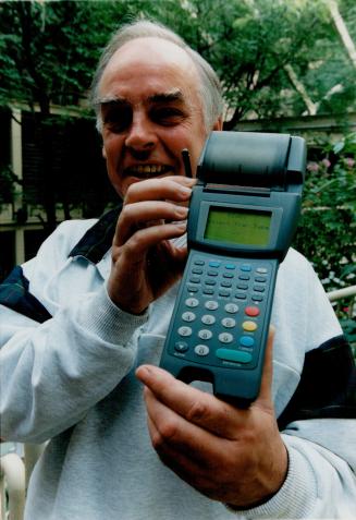 Easier to pay: Scotiabank official Ed Lomax holds wireless terminal that processes credit or debit card purchases without need to run to the counter