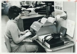 Relaying message from deaf person's home, switchboard operator Bonnie Evans uses teletype machine at Metro police headquarters. About 175 deaf people (...)