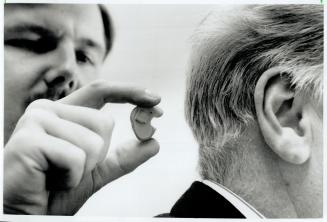 The Better To Hear You: Audiologist Donald Hayes fits Jim McTague with a device that makes it easier for him to hear soft sounds