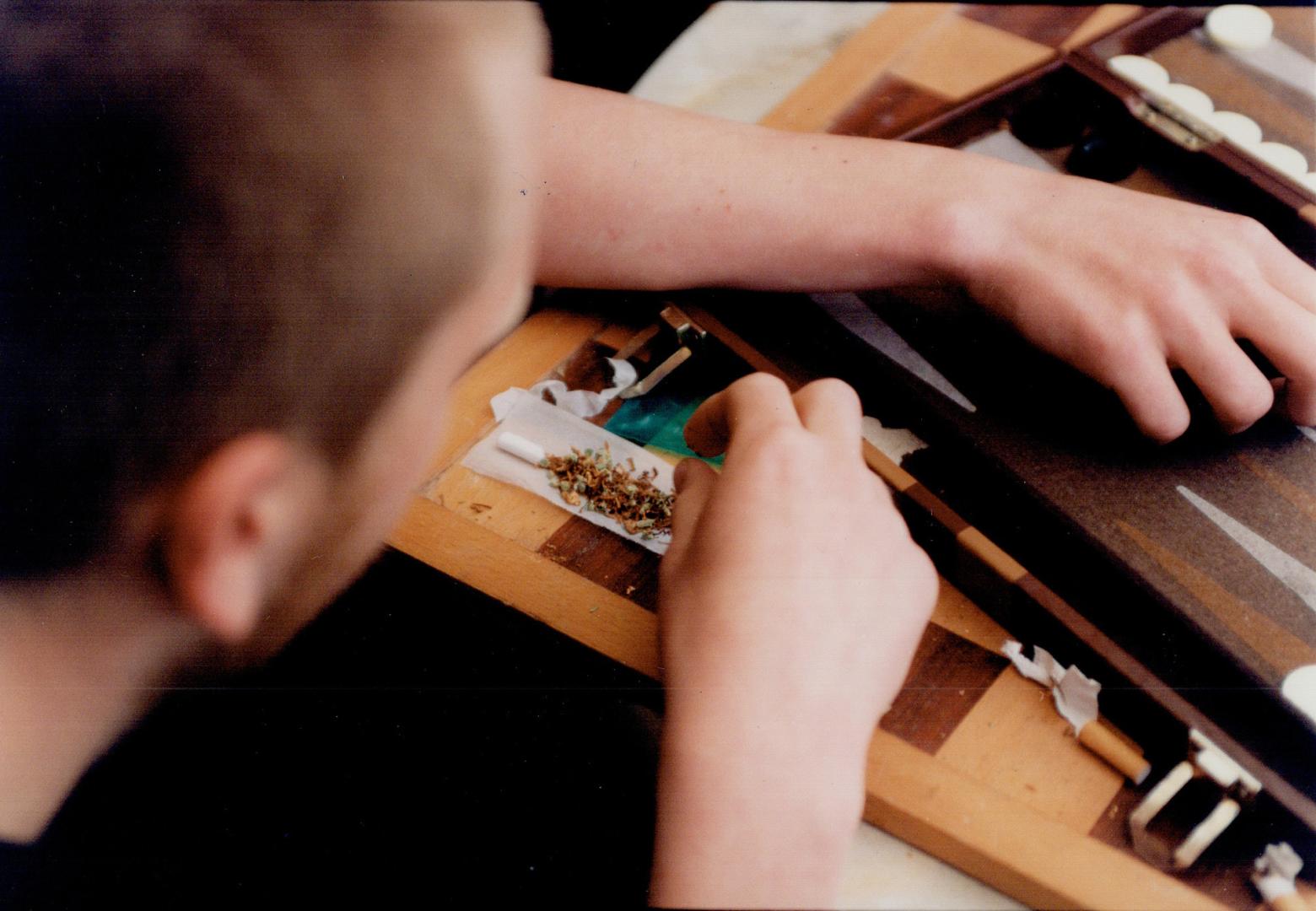 Rolling a joint with a blend of tobacco and hashish, Austerdam