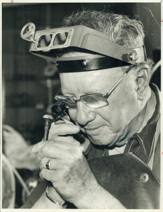 Lapidary student Cliff Ireland, 60, checks over a polished stone at Central Technical School